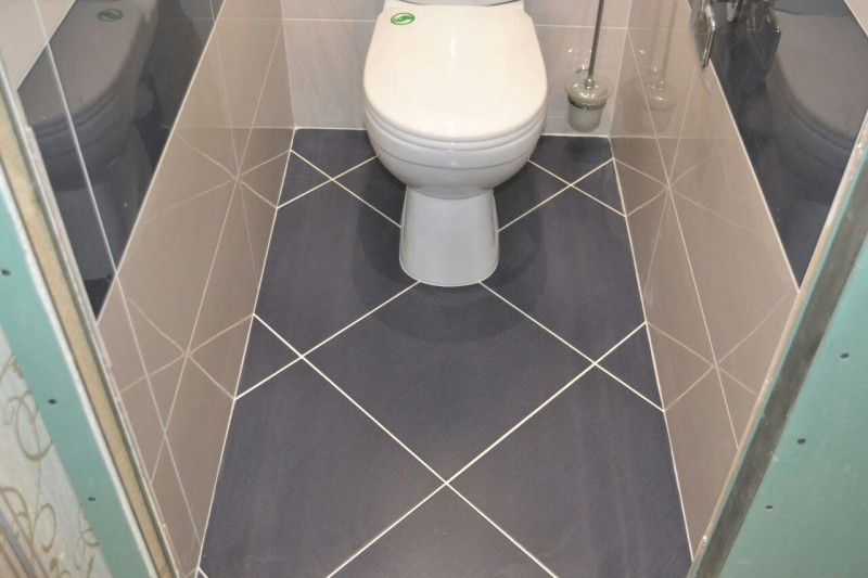 Диагональная укладка серой плитки на полу туалета