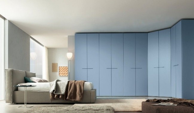 Корпусный угловой шкаф голубого цвета в современной спальне